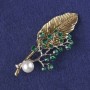 Brooch-pendant Sprig with green crystals, white bead, gold and silver metal 76x33mm+